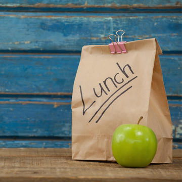 Sacchetto di carta per lunch con vicino una mela verde